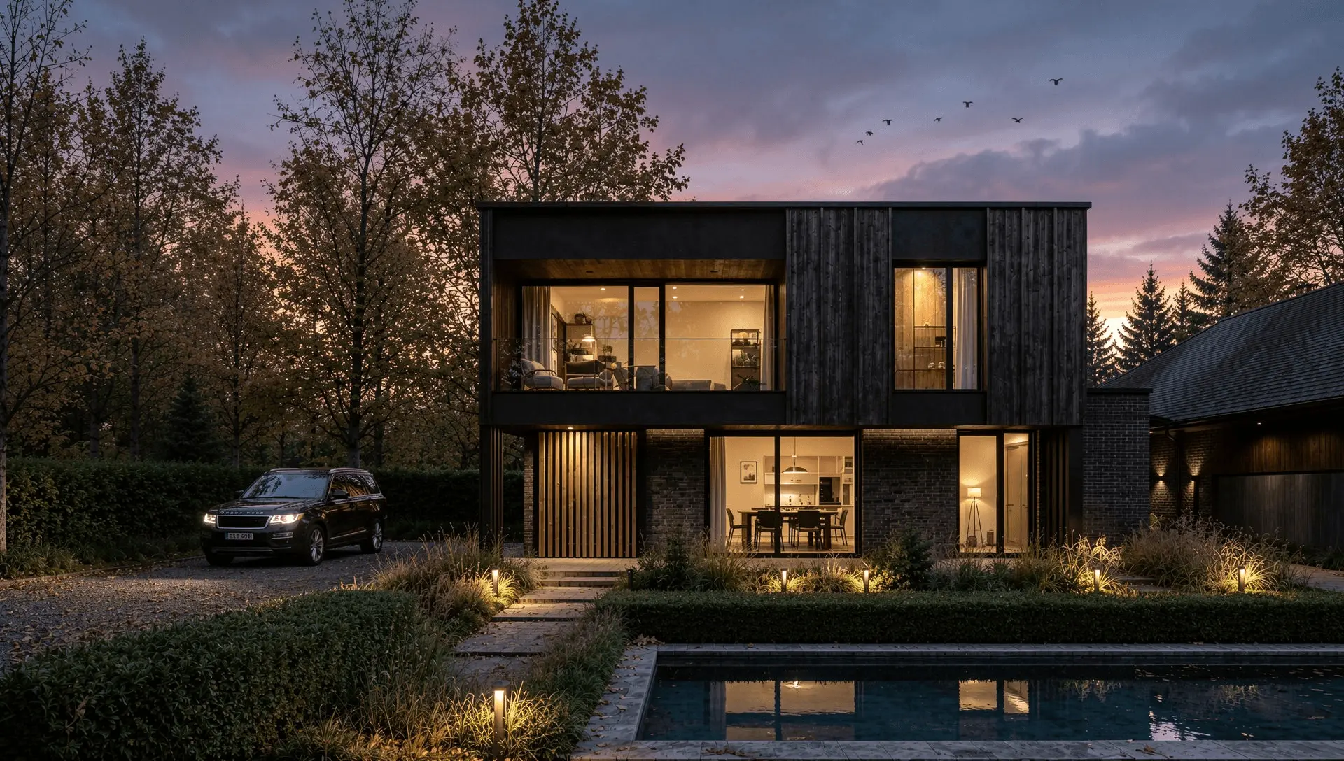 CGI render of the black timber-clad dwelling on Worsley Road, Gurnard, at dusk with the pool terrace lit